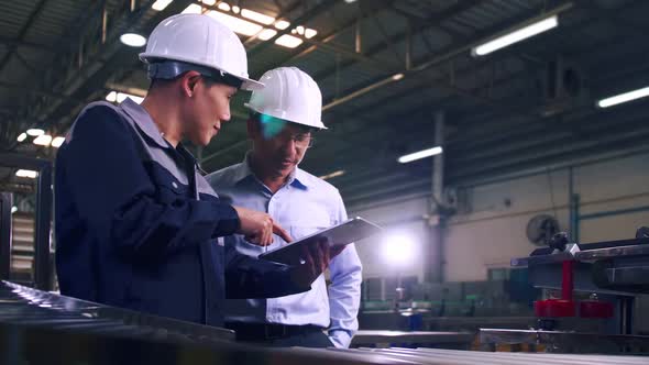 An engineer is explaining remote machine control to industrial owners. alt