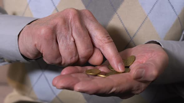Senior Male Counting Euro Cents in Hand Closeup, Pension Insurance, Poverty alt