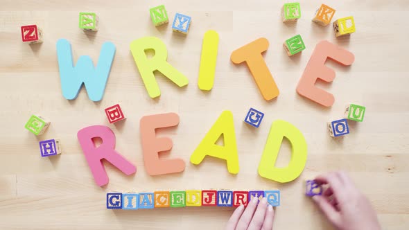 Time lapse. Words READ and WRITE from multicolor wooden letters on wooden table. alt