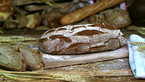 Two Slices of Crusty Bread and A Whole Loaf of Bread on A Table Close-Up alt