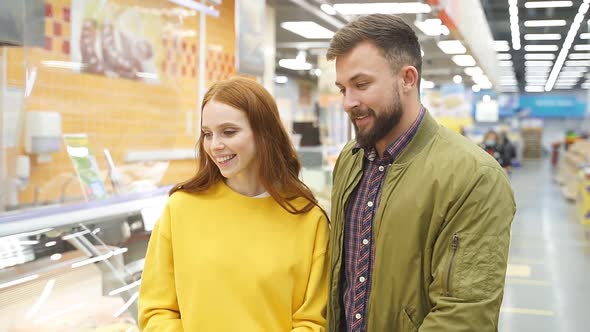 Lovely Married Couple Walk in Grocery Store Choosing Food for Home