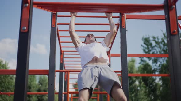 Motivated Sportsman Training Hand Muscles on Sport Equipment in Park Outdoors alt