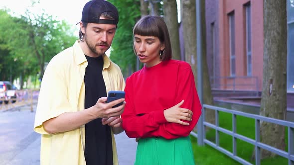 Attractive Couple Using Phone on Street and Getting Wow Gesture Super Happy alt