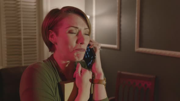 A woman is shaking and calling a number to help get rid of ghosts. alt