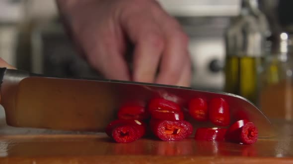 Cook Cuts A chili Pepper By A Knife alt