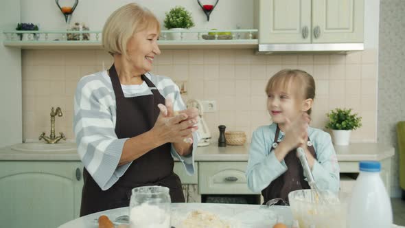 Happy Family Granny and Little Girl Making Pastry From Dough at Home in Kitchen alt