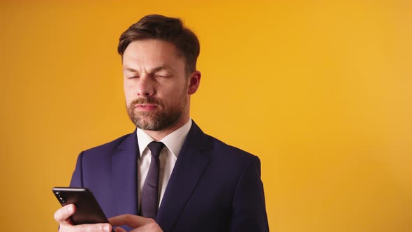 Thoughtful Businessman Holding Smartphone , Texting or Reading Rumors alt