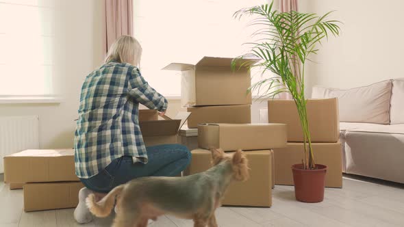 A Blonde Woman is Getting Ready to Move Into a New Home