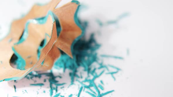 Turquoise color pencils shavings on a white background alt