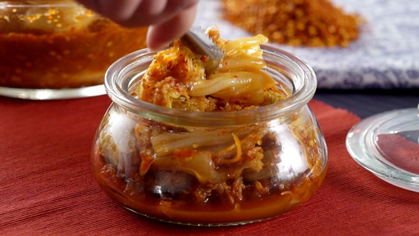 Korean Kimchi in glass jar with red background