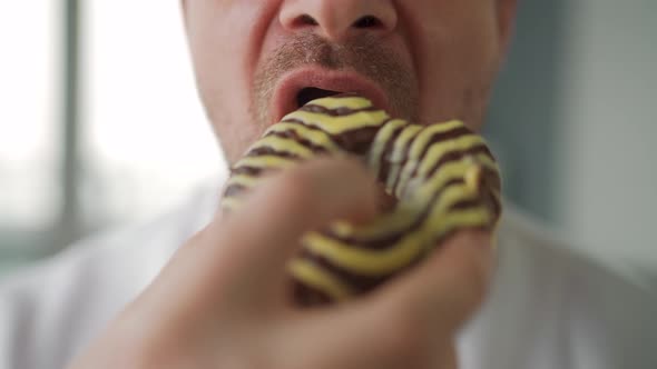 Man Eating Sweet Chocolate Donut alt