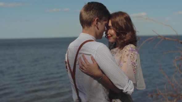 The Guy Comes Up to the Girl Hugs and Strokes Her Hair the Girl Smiles at Him alt