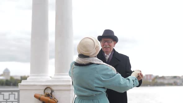 Senior man and woman dancing together in the park. The concept of a healthy lifestyle. alt