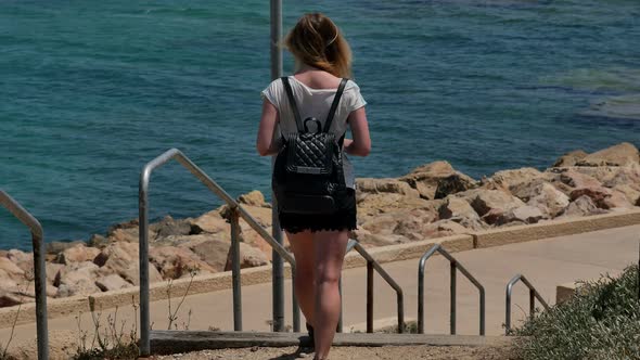 Young Girl Walking Down the Stairs To the Sea alt