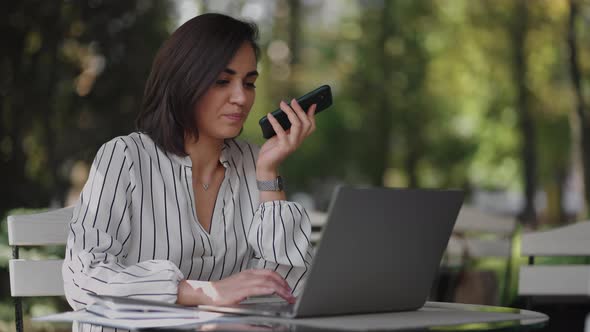 Confident Business Woman Recording Audio Message on Smartphone at Street alt
