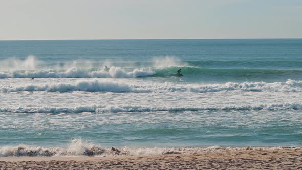 Surfer catching blue waves of the Atlantic Ocean on a beautiful sunny day alt