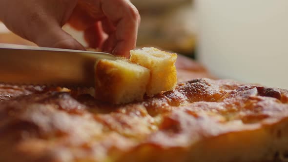 Cutting bread made with cassava flour harvested from organic farms in the Amazon rainforest into cub alt