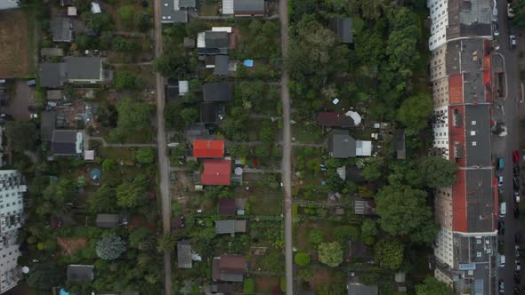 Aerial Birds Eye Overhead Top Down Panning View of Low Family Houses with Gardens Among Multistorey alt
