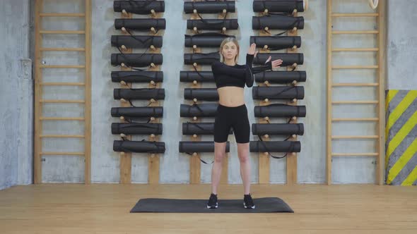 Young Girl Doing Hand Warm-Up for Workout, Stretching Muscles for Training in the Gym alt