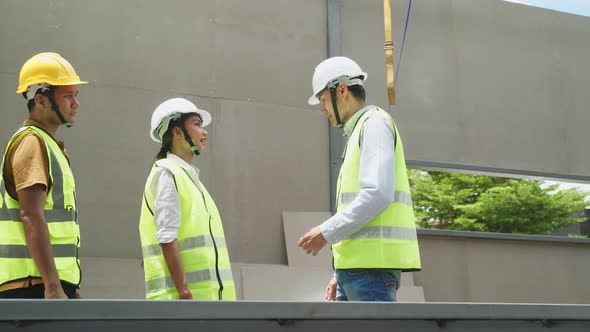 Asian structure engineer and worker making handshake on building work in construction workplace. alt