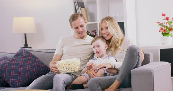 Portrait of a Family of Four Watching Tv in Living Room alt
