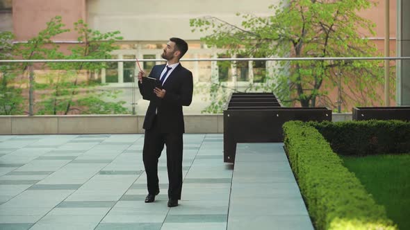 Evil Businessman Walks Down the Street and Makes Notes on the Tablet alt