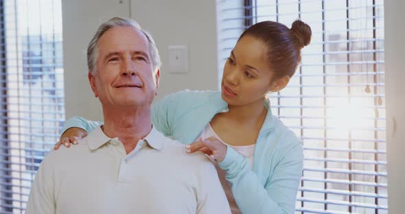 Physiotherapist giving shoulder massage to senior patient 4k alt