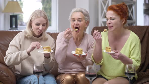 Front View Portrait of Three Happy Adult Caucasian Slim Women Tasting Delicious Cake Smiling Talking alt
