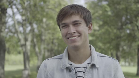 Closeup Portrait of Happy Young Caucasian Man Looking at Camera and Laughing Out Loud alt