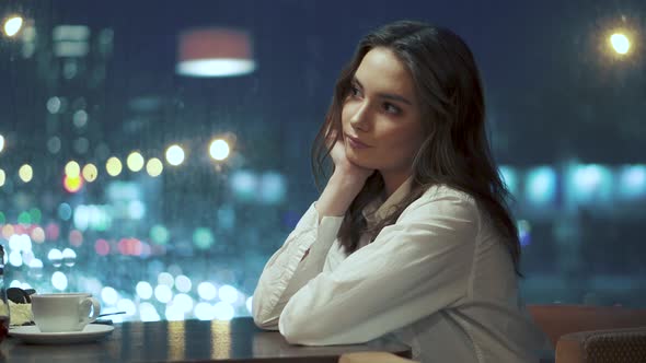 Portrait of a Cute Young Girl on the Background of the Lights of the Night City alt