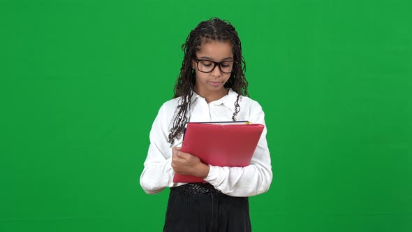 Portrait of Nerd African American Teen Girl in Eyeglasses Looking Through Notes in Workbook Sighing alt