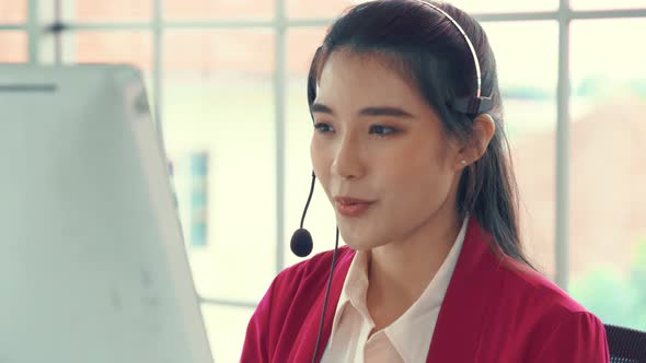 Businesswoman Wearing Headset Working Actively in Office alt