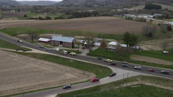 aerial view of fire and rescue vehicles on a rural highway in rain in autumn.  Farm field.