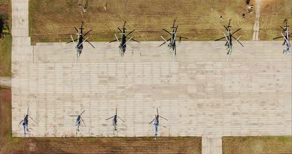 Aerial View Helicopters Stand in Rows at the Airfield