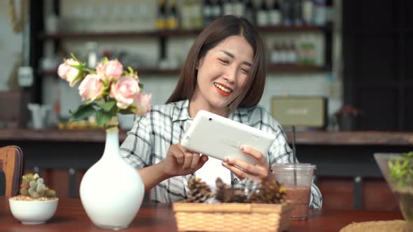 happy woman using digital tablet in a cafe
