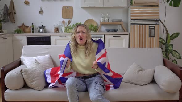 Emotional Woman Sports Fan of the UK National Team at Home with the United Kingdom Flag alt