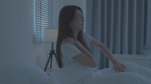 Asian beautiful sick girl in pajamas getting up from sleep in bedroom. alt