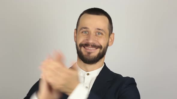 Handsome Young Businessman Smiling and Actively Clapping Hands, Greeting New Customers