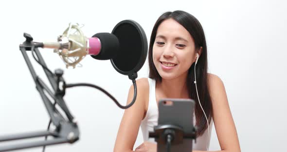 Woman making live stream on cellphone  alt