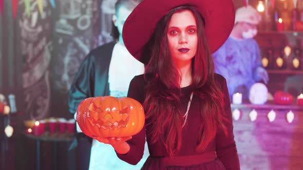 Young Beautiful Woman in Black Witch Costume at a Halloween Party alt