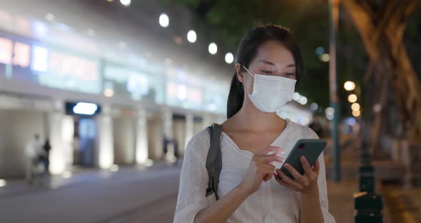 Woman wear face mask and use of mobile phone at street