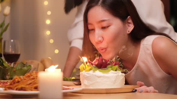 Asian couple celebrate birthday party with cake together at home. alt