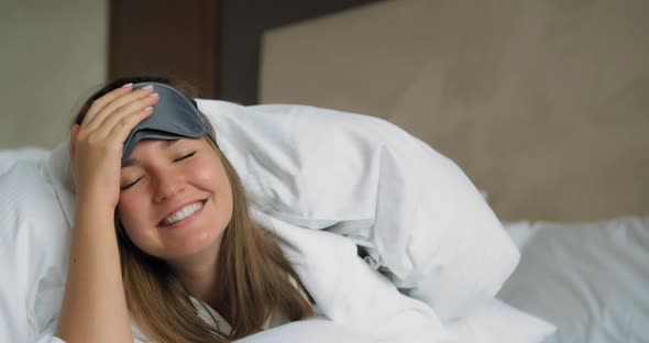 Woman Takes Off Sleep Mask Lying Under Soft Blanket on Bed