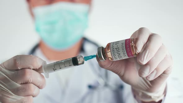 Asian Doctor Holding A Syringe With Liquid Vaccines For Children Or Older Adults alt