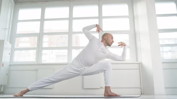 Man Practicing Yoga Standing in Variation of Warrior I Posture or Virabhadrasana