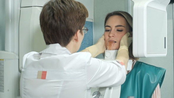 Attractive young girl doing examination of teeth by using alt