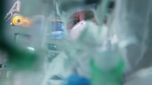 Dentist in Coverall Leaning Over Patient Putting Oxigen Mask alt