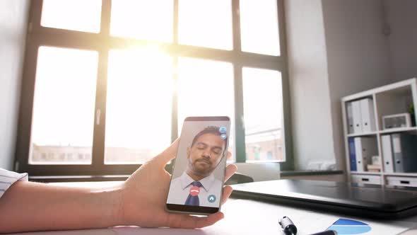 Hand Holding Smartphone with Video Call at Office alt