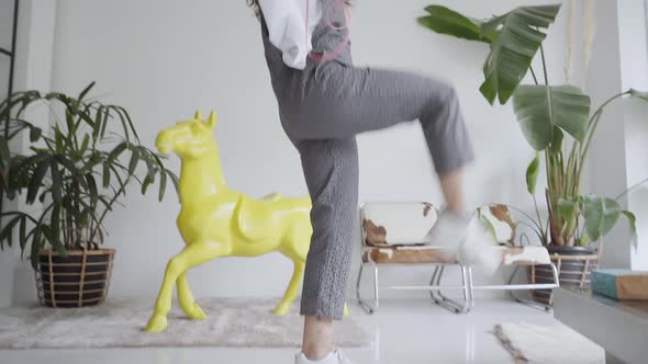 Happy Young Woman Dances at Home Listening to Music on Headphones alt