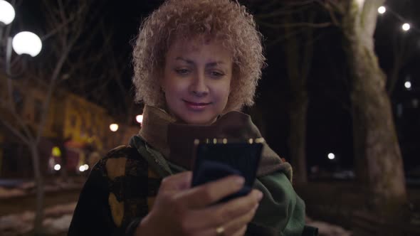 Beautiful Caucasian Woman in Using Smartphone or Cell Phone on the Street